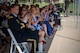 group of people in an audience applaud during a ceremony.