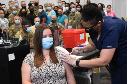 Emma L. Jenks, 21, of Millerton, New York, gets one of the last vaccinations at the Jacob K Javits mass vaccination site in Manhattan July 9, 2021. Jenks, the daughter of New York Army National Guard Sgt. Major Robert, received her second Pfizer vaccination from nurse Christina Davis-Riley and New York Air National Guard Tech. Sgt. Mark Manual, a member of the 105th Airlift Wing, who served as the data entry technician. Representatives from the agencies that comprised Joint Task Javits witnessed the occasion.