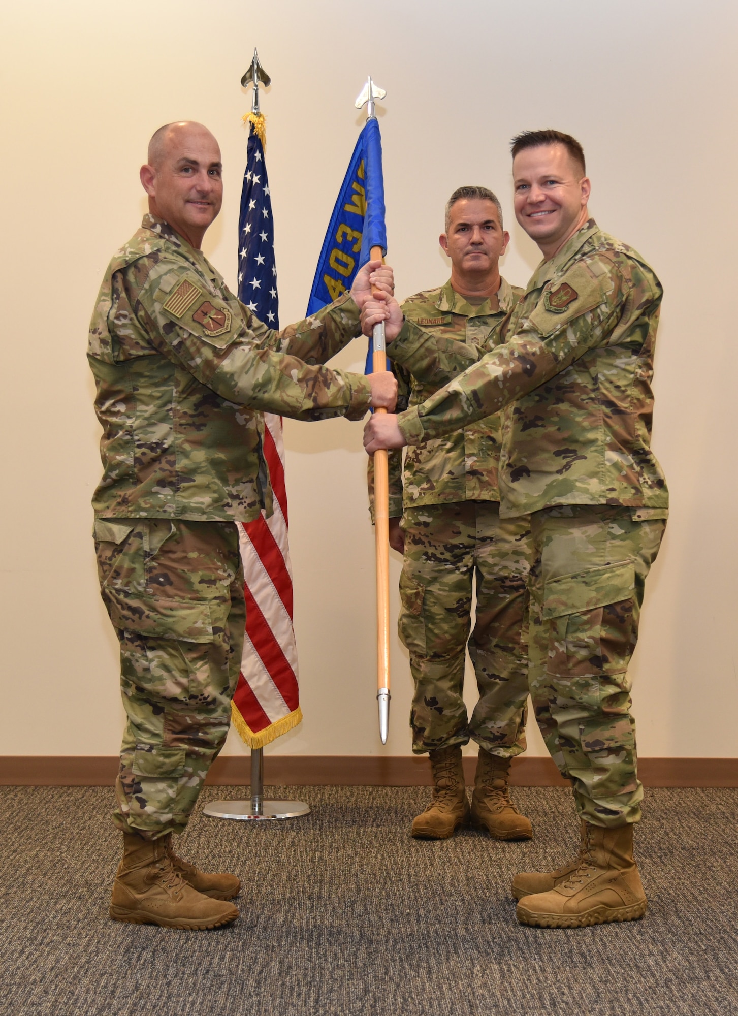 Col. Steven W. Fortson, 403rd Maintenance Group commander, passes the 403rd Maintenance Squadron guidon to Maj. Keith J. Johnson Jr., 403rd MXS commander, during the change of command ceremony July 10, 2021 at the Roberts Consolidated Aircraft Maintenance Facility auditorium on Keesler Air Force Base, Miss. The squadron provides comprehensive organizational and intermediate maintenance and inspection supporting the flying operations of the 403rd Wing.  (U.S. Air Force photo by Tech. Sgt. Michael Farrar)