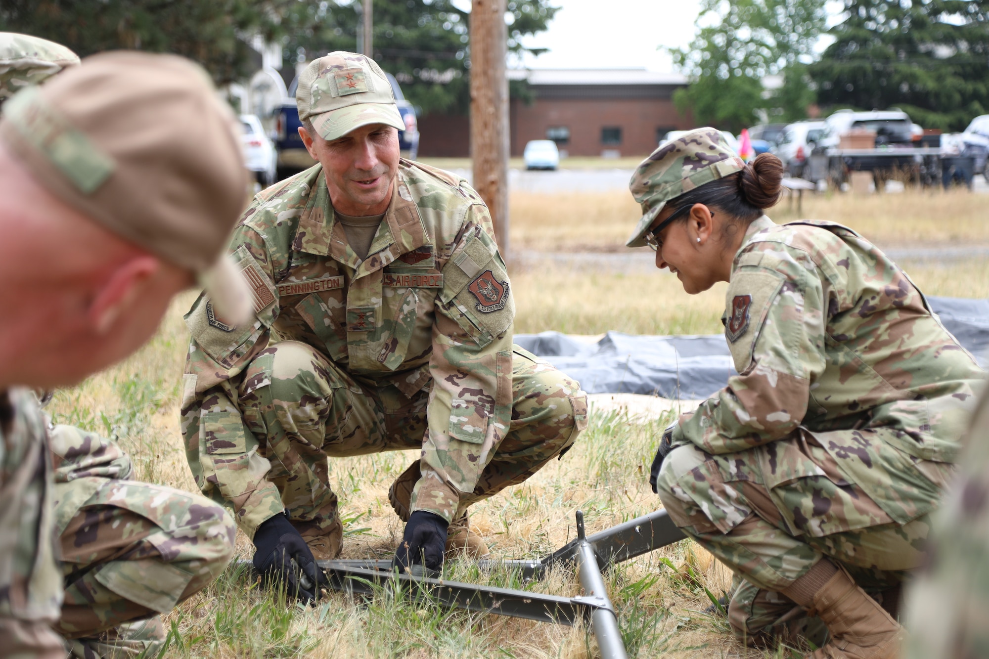 4 AF leaders help build at tent on McChord Field.