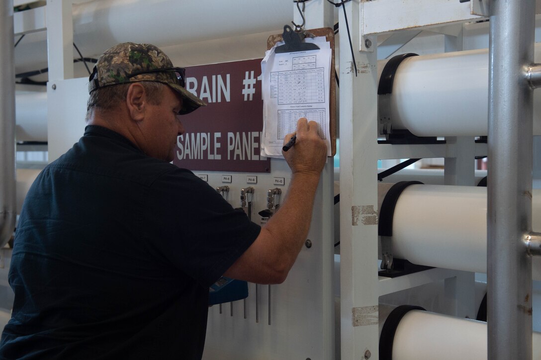 A photo of a man writing on document.