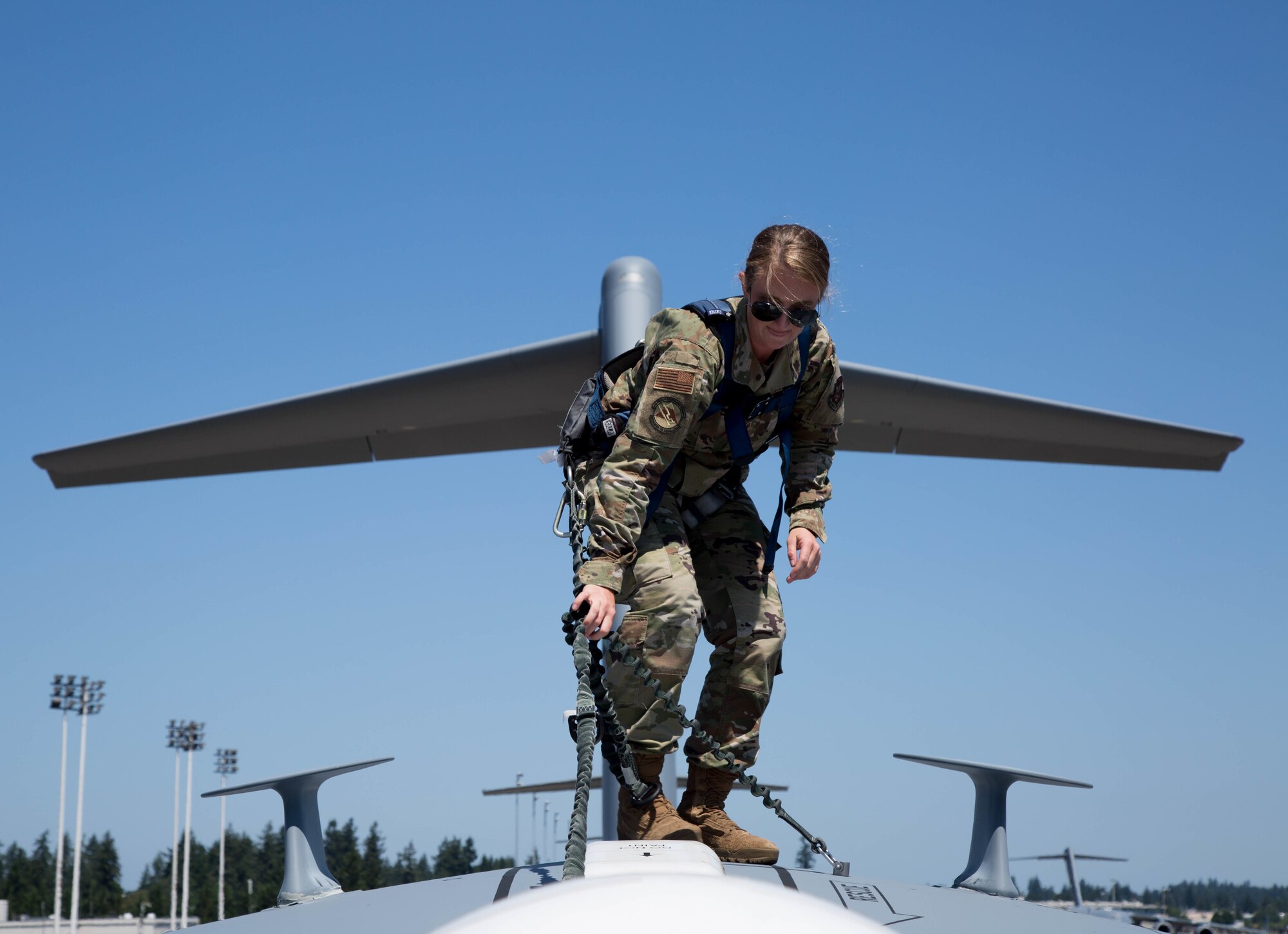 Airman inspects the top of a C-17 Globemaster III aircraft.