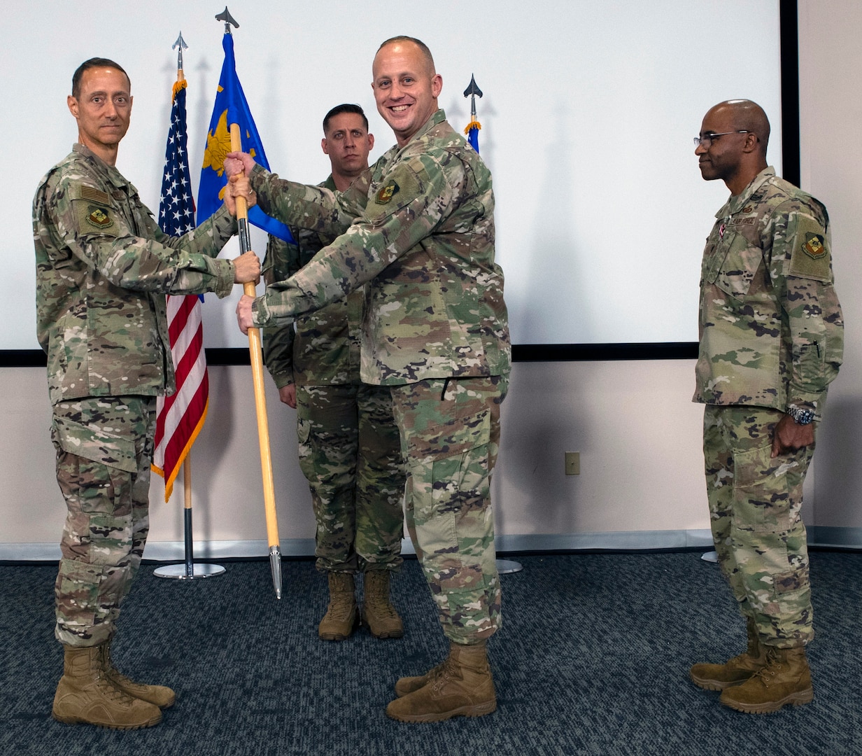 U.S. Air Force Maj. Karl Wiest accepts the guidon from U.S. Air Force Lt. Col. Greg Hignite, Air Force Public Affairs Agency commander, during a change of command ceremony.