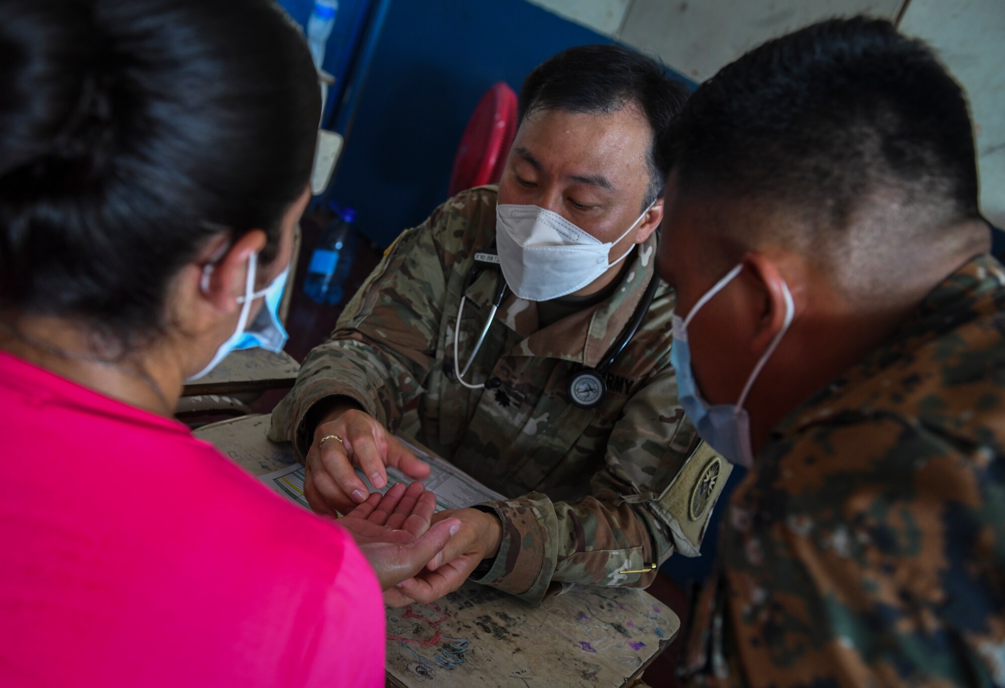 U.S. Army Lt. Col. Jeehun Kim, a medical provider with the Medical Element, Joint Task Force-Bravo, Soto Cano Air Base, Honduras, examines the hands of a patient during a medical readiness training exercise site for Resolute Sentinel 21 at Meanguera Island, El Salvador, May 14, 2021. Two medical providers saw 93 patients during the exercise.