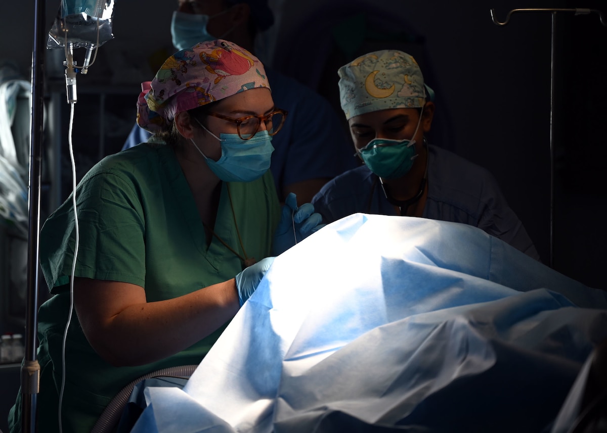 U.S. Air Force Capts. Courtney Hood and Kimpreet Kaur, anesthesia residents with the 59th Medical Wing, Joint Base San Antonio-Lackland, Texas, evaluate a patient at Hospital del Sur in Choluteca, Honduras, May 25, 2021. U.S. military doctors arrived in Choluteca for a urologic surgical readiness training exercise to provide essential surgeries to pre-selected Honduran patients.