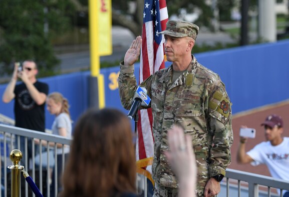 U.S. Air Force Col. William Hunter, 81st Training Wing commander, recites the oath of office to 10 Air Force delayed entry program recruits during the Biloxi Shuckers Minor League Baseball game in Biloxi, Mississippi, July 10, 2021. Hunter also threw the first pitch during pre-game festivities. (U.S. Air Force photo by Kemberly Groue)