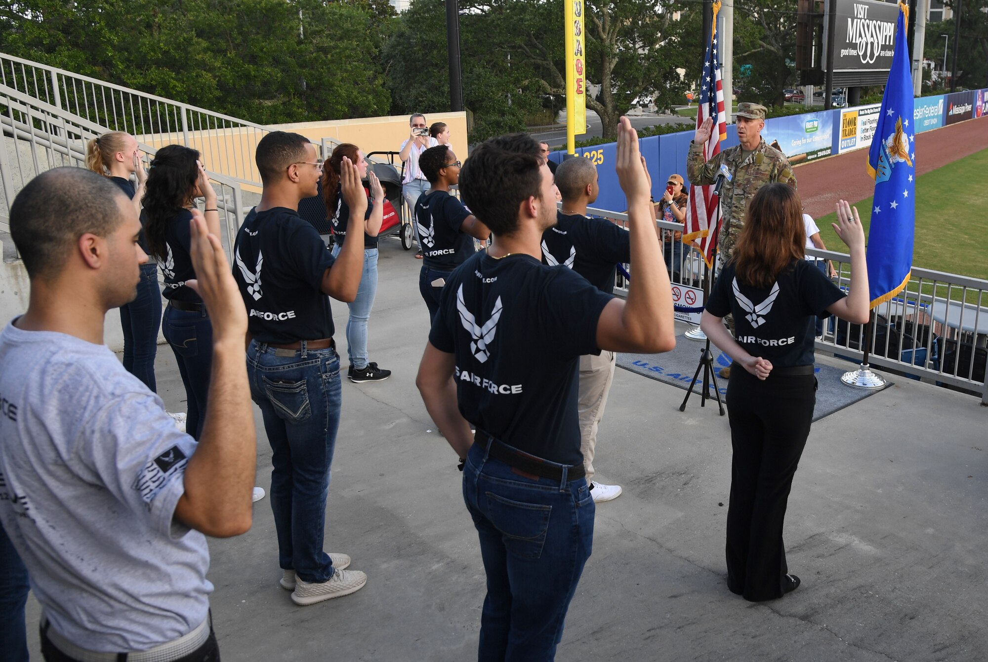U.S. Air Force Col. William Hunter, 81st Training Wing commander, recites the oath of office to 10 Air Force delayed entry program recruits during the Biloxi Shuckers Minor League Baseball game int Biloxi, Mississippi, July 10, 2021. Hunter also threw the first pitch during pre-game festivities. (U.S. Air Force photo by Kemberly Groue)