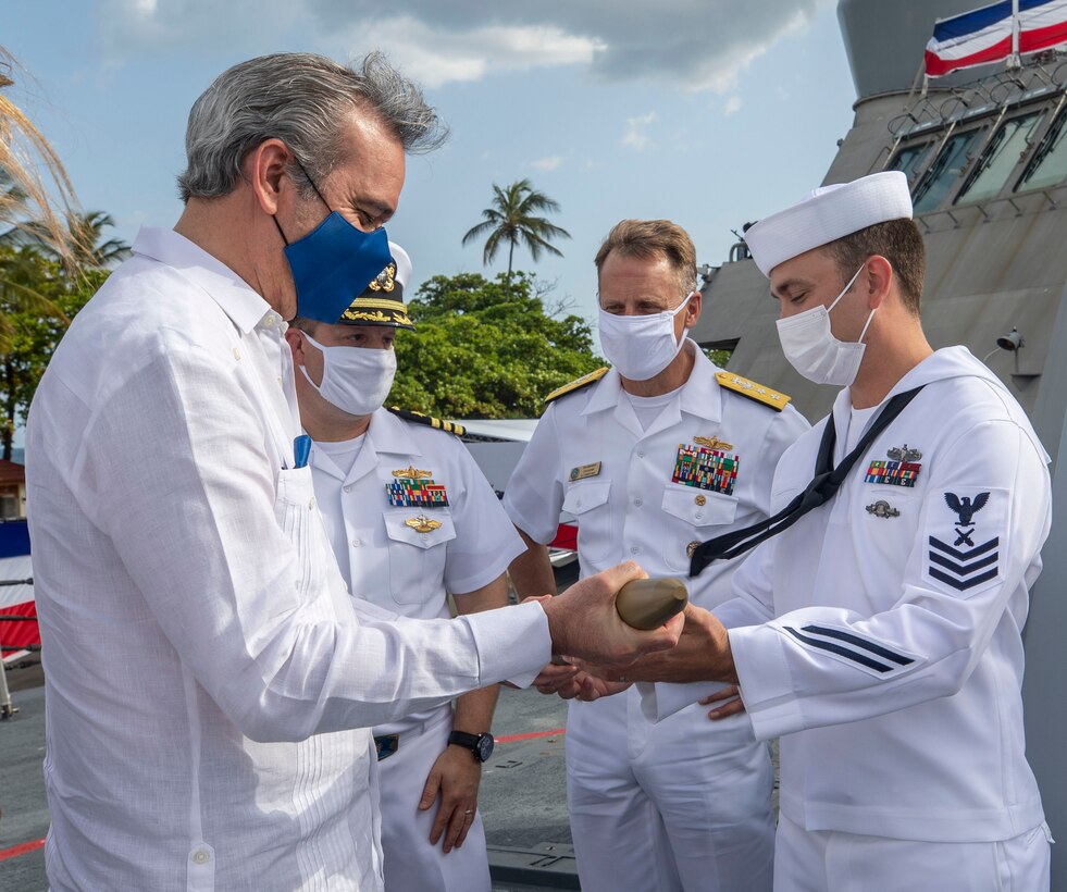 His Excellency Luis Rodolfo Abinader Corona, President of the Dominican Republic, examines a practice round from the 57mm gun during a tour of the fo’c’sle aboard USS Billings (LCS 15), July 9.