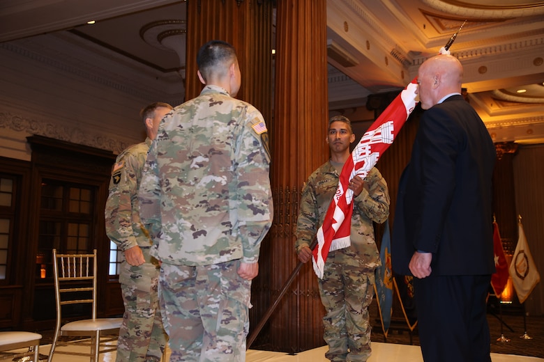 Incoming Commander LTC Ramon Brigantti accepts the colors from BG Thomas Tickner during the July 9 2021 Change of Command ceremony.