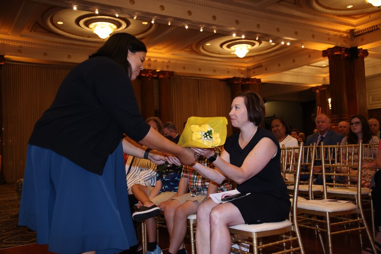 LTC Crystal Brigantti, spouse of LTC Ramon Brigantti, receives flowers from Denise Roberts during the 2021 Change of Command ceremony