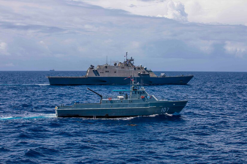 Two ships sail in blue waters.