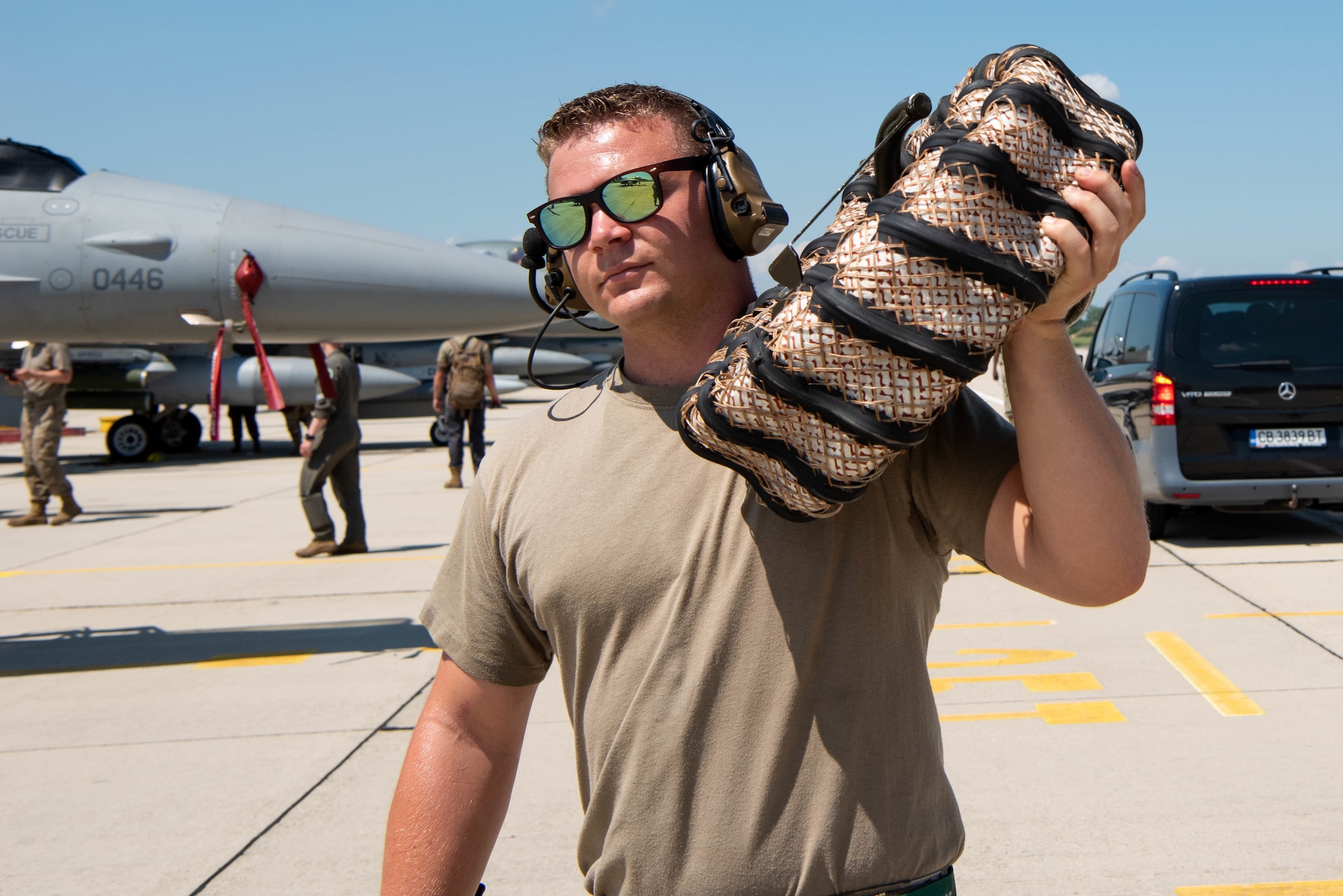 An avionics technician assigned to the 555th Aircraft Maintenance Unit carries a hose at Graf Ignatievo Air Base, Bulgaria, July 9, 2021. The 555th Fighter Squadron is participating in exercise Thracian Star 21, a Bulgarin air force-led exercise aiming to maximize interoperability, combat effectiveness and survival awareness while operating in a dynamic high-threat environment. (U.S. Air Force photo by Airman 1st Class Brooke Moeder)
