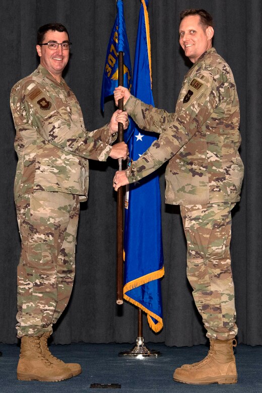 Photo of Airman holding unit guidon