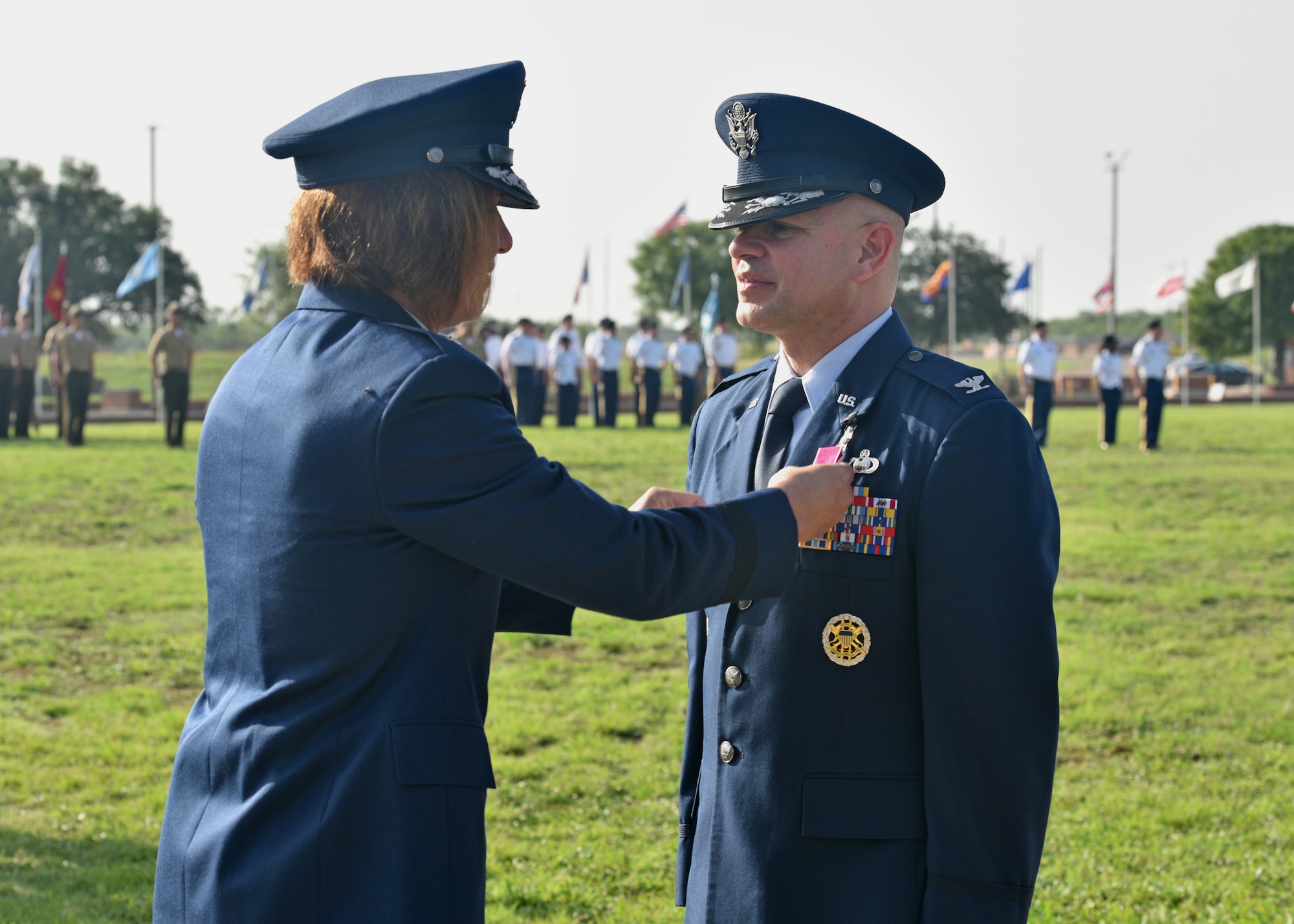 U.S. Air Force Maj. Gen. Andrea Tullos, Second Air Force commander, presents the Legion of the Merit to the 17th Training Wing outgoing commander, Col. Andres Nazario, during the 17th TRW change of command ceremony on Goodfellow Air Force Base, Texas, July 13, 2021. Nazario is transferring to the Pentagon, Washington, D.C. (U.S. Air Force photo by Senior Airman Ashley Thrash)