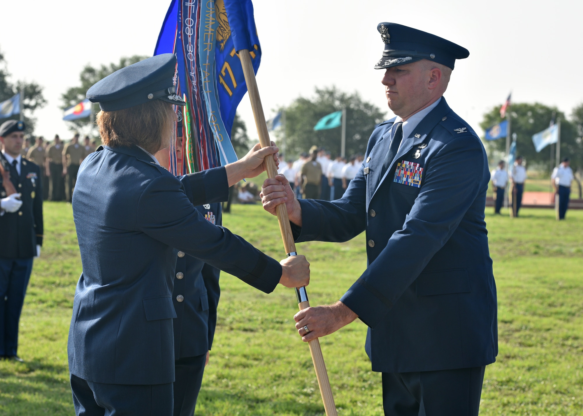 U.S. Air Force Maj. Gen. Andrea Tullos, Second Air Force commander, presents the guidon to incoming commander, Col. Matthew Reilman, during the 17th Training Wing change of command ceremony on Goodfellow Air Force Base, Texas, July 13, 2021. Tullos presided over the ceremony, during which Col. Andres Nazario relinquished command of the 17th TRW. (U.S. Air Force photo by Senior Airman Ashley Thrash)