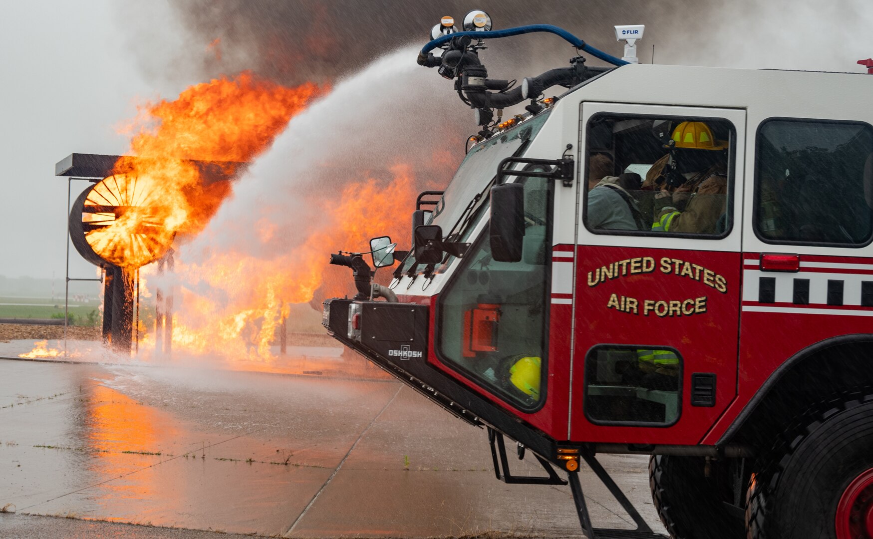 Nevada Air National Guard 152nd Civil Engineer Squadron fire protection specialists utilize an Oshkosh Striker with a mounted water turret to extinguish a fire on a C-130 aircraft frame during a live-burn exercise at Volk Field Air National Guard Base in Wisconsin July 7, 2021.