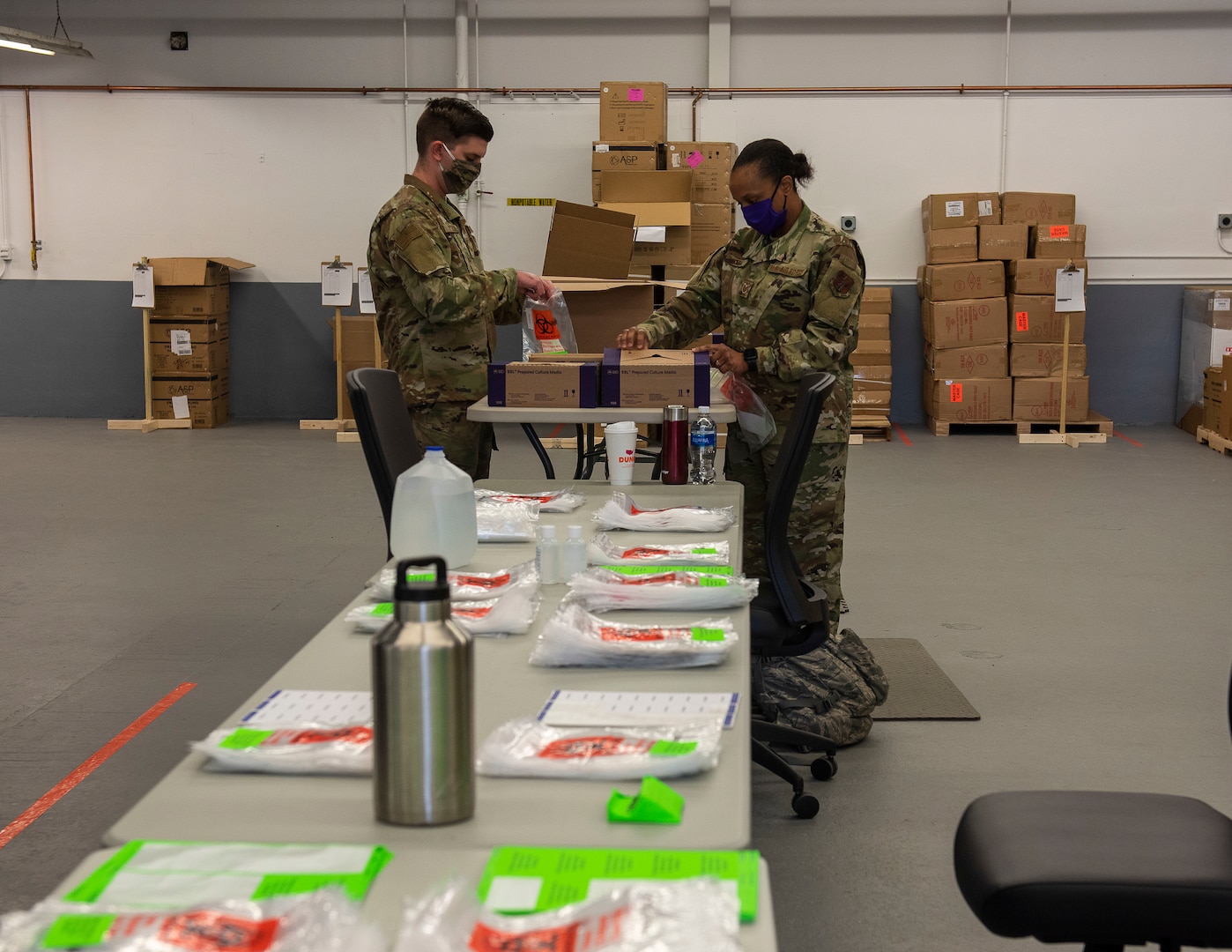 From left, U.S. Air Force Senior Airmen Lucas Wysock and Technical Sgt. Christina McGill, 158th Fighter Wing, Vermont Air National Guard, assemble COVID-19 test kits at the Strategic National Stockpile Warehouse, August 27, 2020. Airmen from across the 158th Fighter Wing have supported operations at the SNS Warehouse since March 2020, and continue to provide critical logistical support to enable Vermont's efforts to distribute Personal Protective Equipment throughout the state and conduct widespread testing for COVID-19. (U.S. Army National Guard photo by Capt. J. Scott Detweiler)
