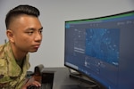 Staff Sgt. Steven De Leon views an unclassified version of a geospatial web application depicting the measurement tool and threat analysis feature of the Phoenix Oracle website. The New Jersey Air National Guardsman is an intelligence analyst with the 204th Intelligence Squadron at Joint Base McGuire-Dix-Lakehurst and has been named the chief lead of the team developing this Air Mobility Command-led web capability project.