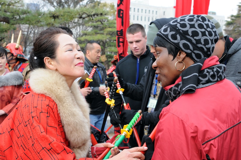 Command Sgt. Maj. Mary L. Brown, battalion command sergeant major for HHBN, U.S. Army Pacific, based at Fort Shafter, Hawaii, greets participant Yoshiko Fujii during the cleanup of the Osaka Castle grounds Jan. 28.