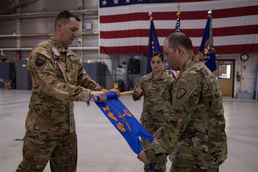 Maj. Daniel Klinkner, left, and Staff Sgt. Cidjomor Fischer furl the company colors during the 2nd Battalion, 641st Aviation Regiment casing ceremony at the unit's aircraft hangar on Joint Base Elmendorf-Richardson, July 9, 2021. The traditional casing ceremony was held as the unit prepares to leave for the mobilization station at Fort Bliss, Texas, prior to deployment overseas. (U.S. Army National Guard photo by Victoria Granado)