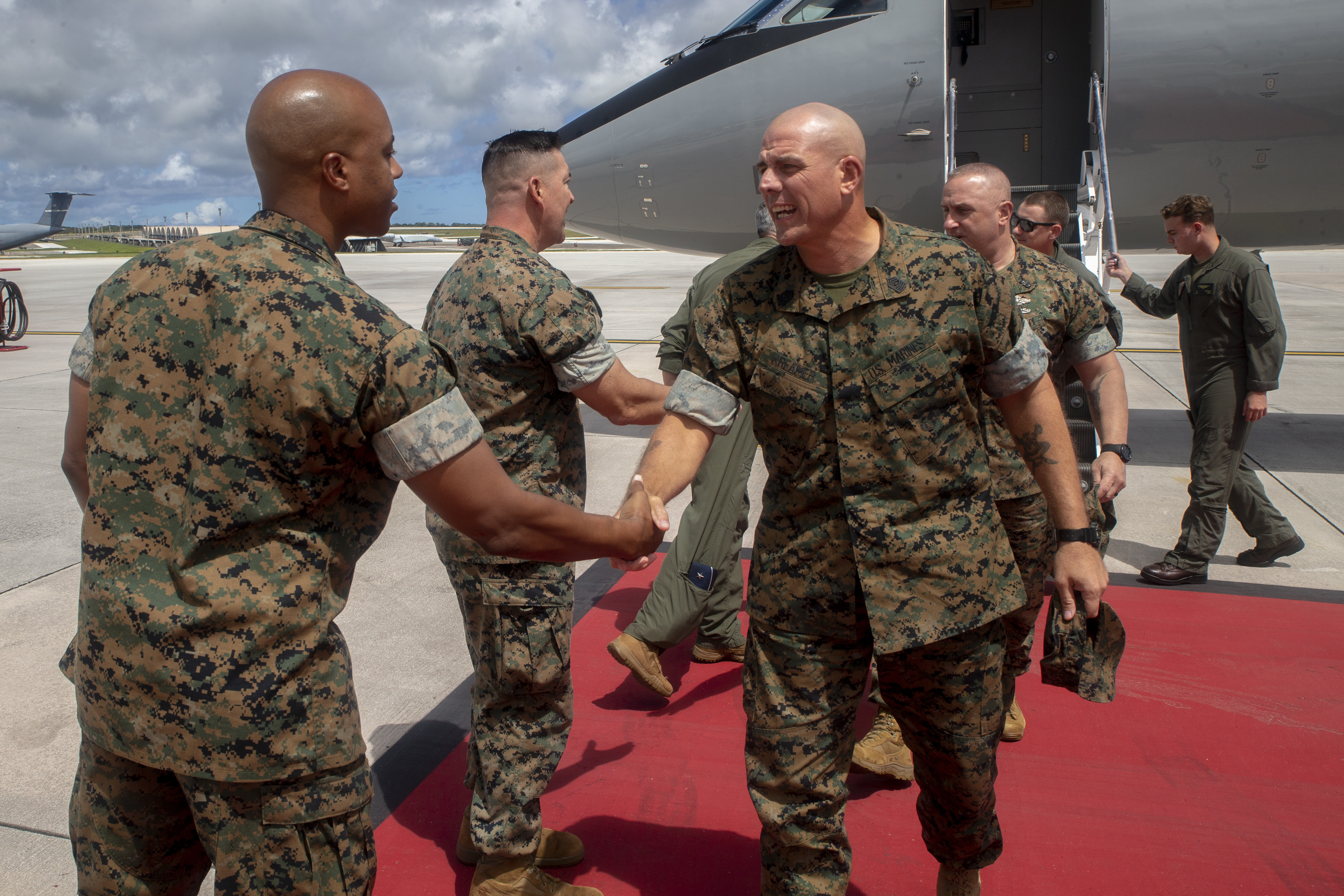 Gunnery Sgt. Kerry Yates, the Marine Corps Base (MCB) Camp Blaz Operations Chief, greets Sgt. Maj. Howard Kreamer, the Marine Forces Pacific Sergeant Major, during a refueling stop on Andersen Air Force Base, July 10, 2021.