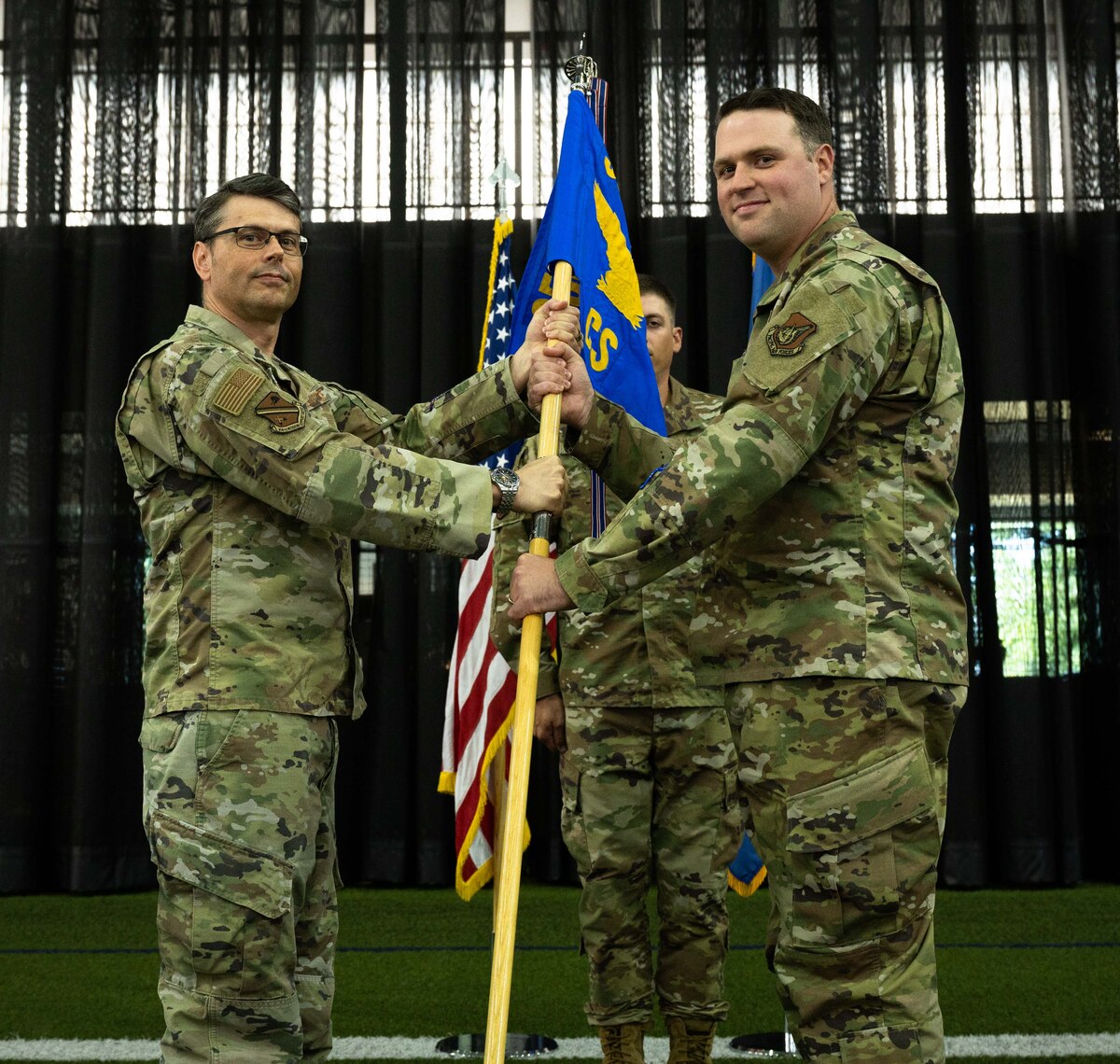 U.S. Air Force Col. Stuart Williamson, the 354th Mission Support Group commander (left), passes the 354th Communications Squadron (CS) guidon to Maj. Daniel Campbell, the 354th CS commander, during a change of command ceremony at Eielson Air Force Base, Alaska, July 9, 2021.