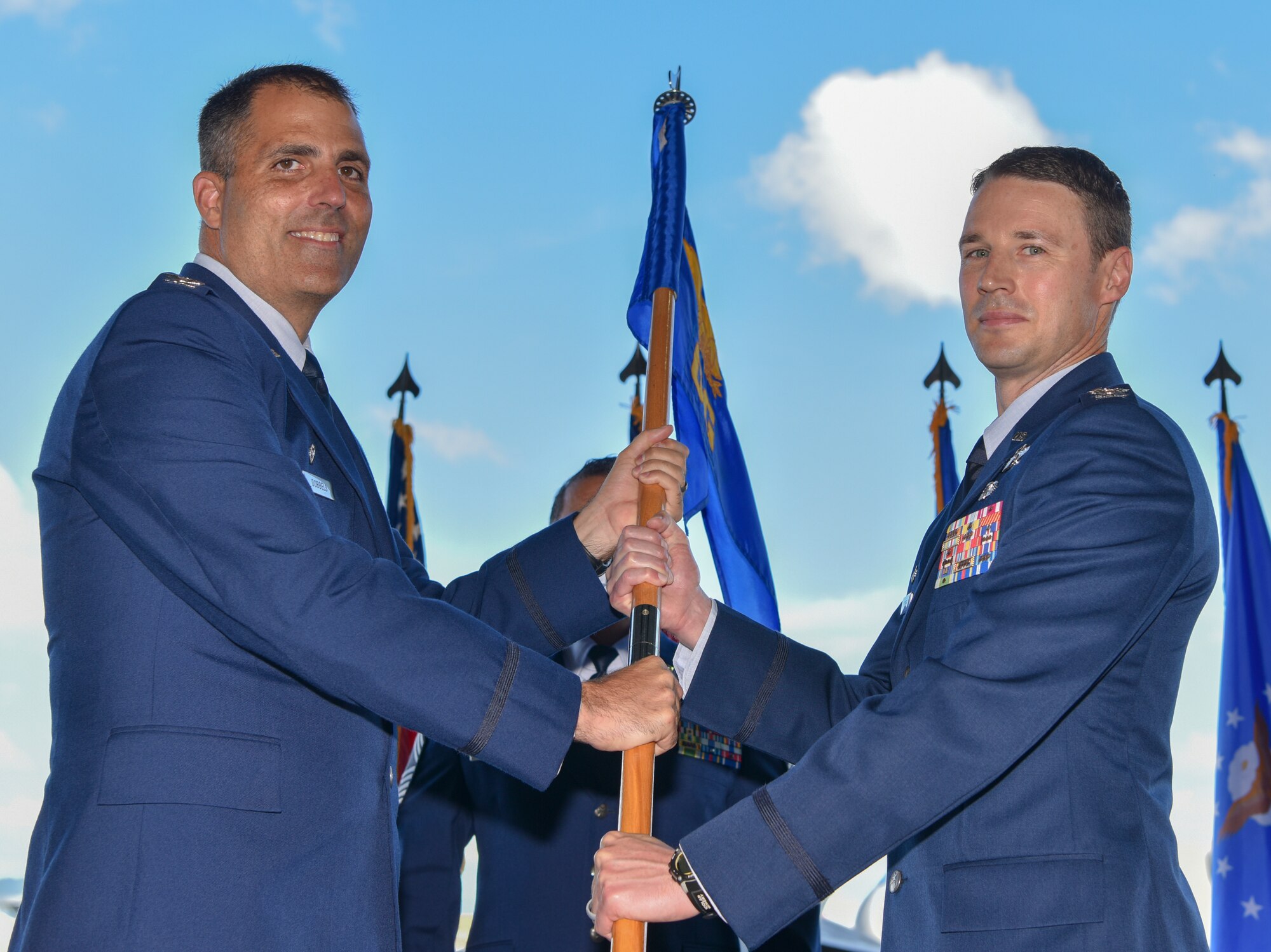 Col. Garrett Fisher, assumes command of the 15th Operations Group by accepting the guidon from Col. Daniel Dobbels, 15th Wing commander, during the 15th OG change of command ceremony at Joint Base Pearl Harbor-Hickam, Hawaii, July 9, 2021. Established in April, 1992, as part of the objective wing reorganization, the 15th OG assumed responsibility from the 15th Air Base Wing for managing operational matters at Hickam AFB, Bellows AFS, and Wake Island Airfield. (U.S. Air Force photo by Tech. Sgt. Anthony Nelson Jr.)