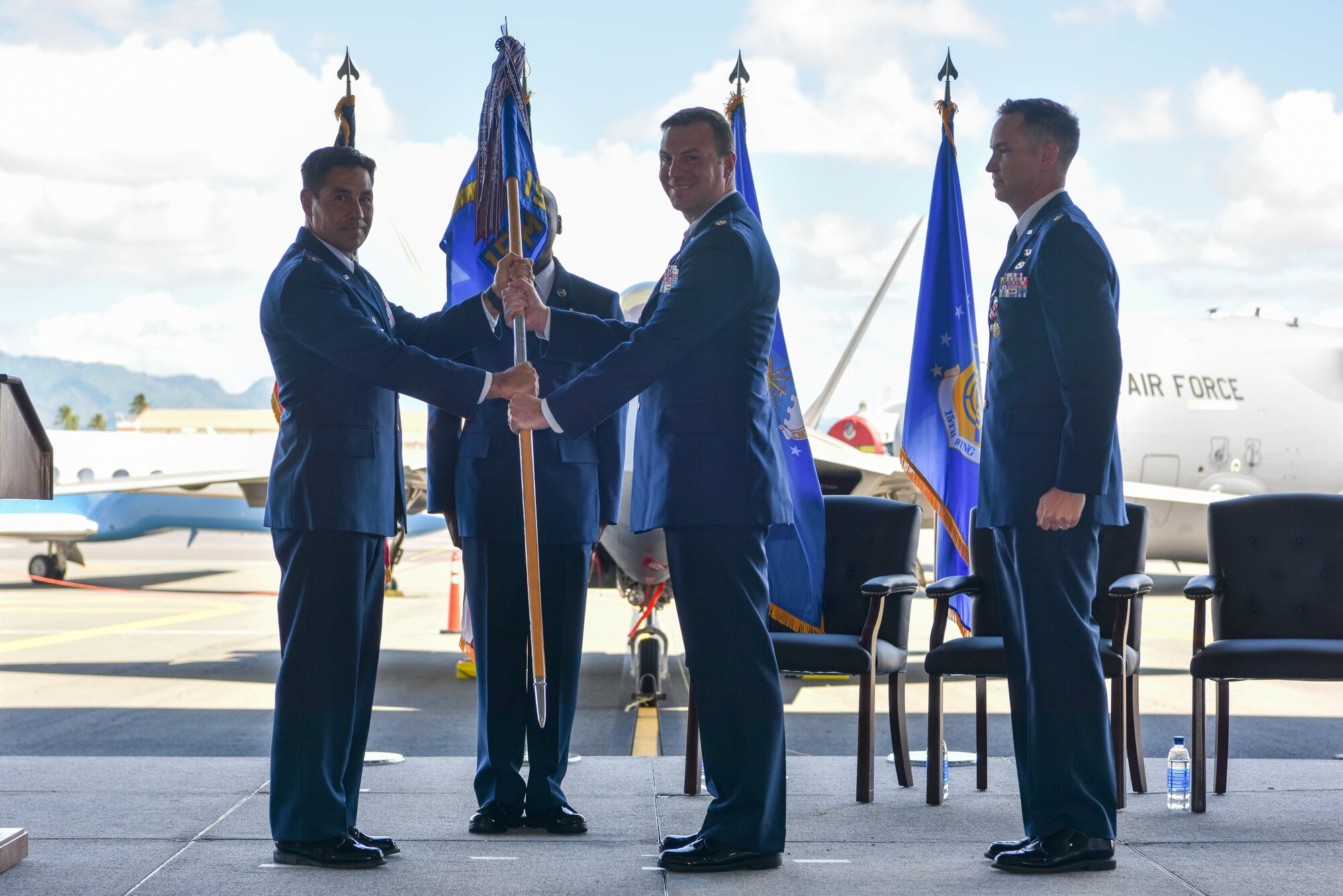 Maj. Jonathan Schmidt, assumes command of the 15th Maintenance Squadron by accepting the guidon from Col. Robert Blake, 15th Maintenance Group commander, during the 15th MXS change of command ceremony at Joint Base Pearl Harbor-Hickam, Hawaii, July 9, 2021. The maintenance group consists of two squadrons, each with specific functions supporting the C-17, and F-22. (U.S. Air Force photo by Airman 1st Class Makensie Cooper)