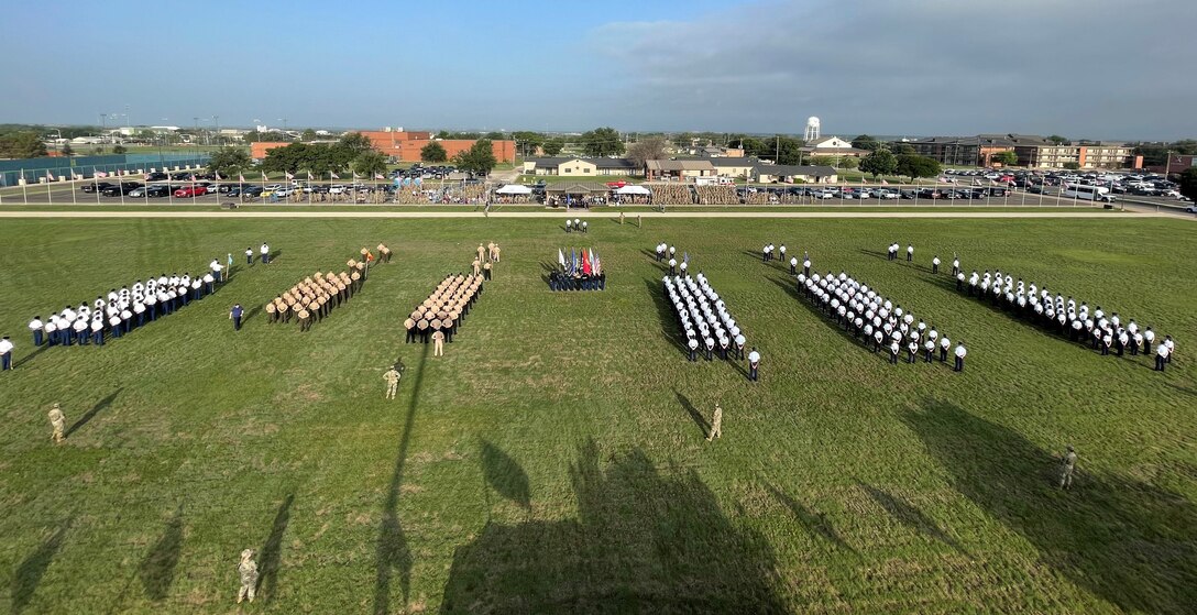 Joint service members assigned to Goodfellow Air Force Base stand in formation for the 17th Training Wing change of command ceremony on Goodfellow Air Force Base, Texas, July 13, 2021. At the ceremony, Col. Matthew Reilman, incoming commander, assumed command from Col. Andres Nazario, 17th TRW outgoing commander. (U.S. Air Force photo by Senior Airman Abbey Rieves)