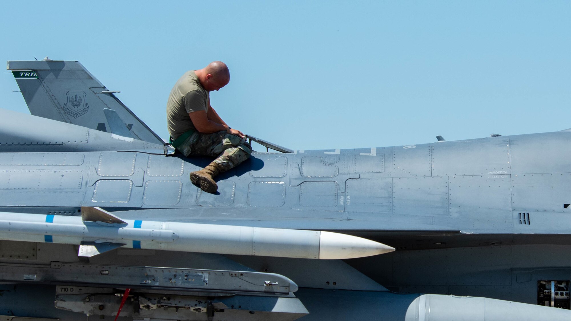 An F-16 Fighting Falcon crew chief assigned to the 555th Aircraft Maintenance Unit performs maintenance on a U.S. Air Force 555th Fighter Squadron F-16 during exercise Thracian Star 21 at Graf Ignatievo Air Base, Bulgaria, July 9, 2021. Thracian Star 21 is a multilateral training exercise with the Bulgarian air force that increases operational capacity, capability and interoperability with Bulgaria. (U.S. Air Force photo by Airman 1st Class Brooke Moeder)