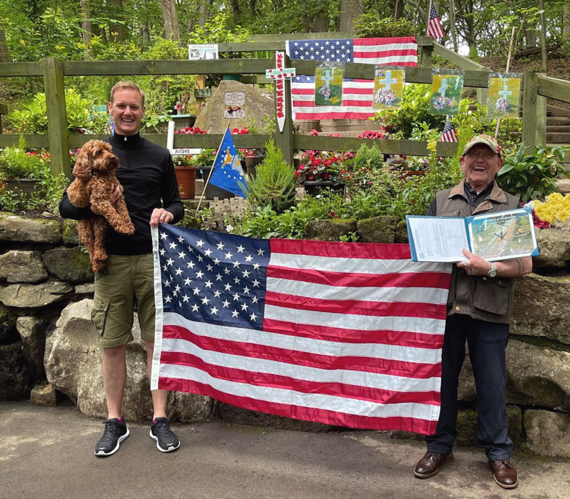 Tony Foulds, right, and Dan Walker pose for a photo with a U.S. flag July 11, 2021, in front of a memorial honoring the U.S. Army Air Forces crew of a B-17 Flying Fortress, “Mi Amigo,” who lost their lives when their aircraft crashed in February 1944 in Sheffield, England. The memorial was vandalized in March 2021 then again in July, and many items including flags were destroyed. Leadership from Royal Air Force Mildenhall sent the flag on behalf of the 100th Air Refueling Wing – which was flown on board a KC-135 Stratotanker aircraft mission over Normandy, France, on the anniversary of D-Day – to place at the memorial in honor of the Mi Amigo crew. Tony has dedicated his life to preserving the memorial built to remember the crew who lost their lives. Walker is a television presenter who met Tony while walking his dog, learned of his story and worked to arrange a flyover in Sheffield to mark the 75th anniversary of the crash in February 2019. (Courtesy photo)
