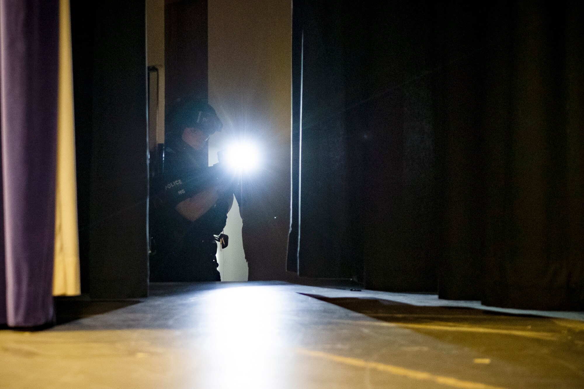 A police officer from the Northamptonshire Police Department, scans for adversaries during a tri-agency active shooter response exercise at RAF Croughton, England, June 30, 2021. Airmen from the 422nd Security Forces Squadron along with police officers from the NHPD and Ministry of Defense, participated in multiple exercises to enhance their search and seizure tactics, strengthen local ties and gain rapport with their fellow officers. (U.S. Air Force photo by Senior Airman Eugene Oliver)