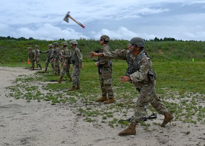 Maj. Gen. David Mikolaities, New Hampshire adjutant general, hurls a hatchet downrange during the New Hampshire National Guard's annual combat marksmanship competition July 10, 2021, at Fort Devens, Mass. The four-day match featured 14 teams and 75 marksmen competing in pistol, rifle, shotgun and even hatchet-throwing events.