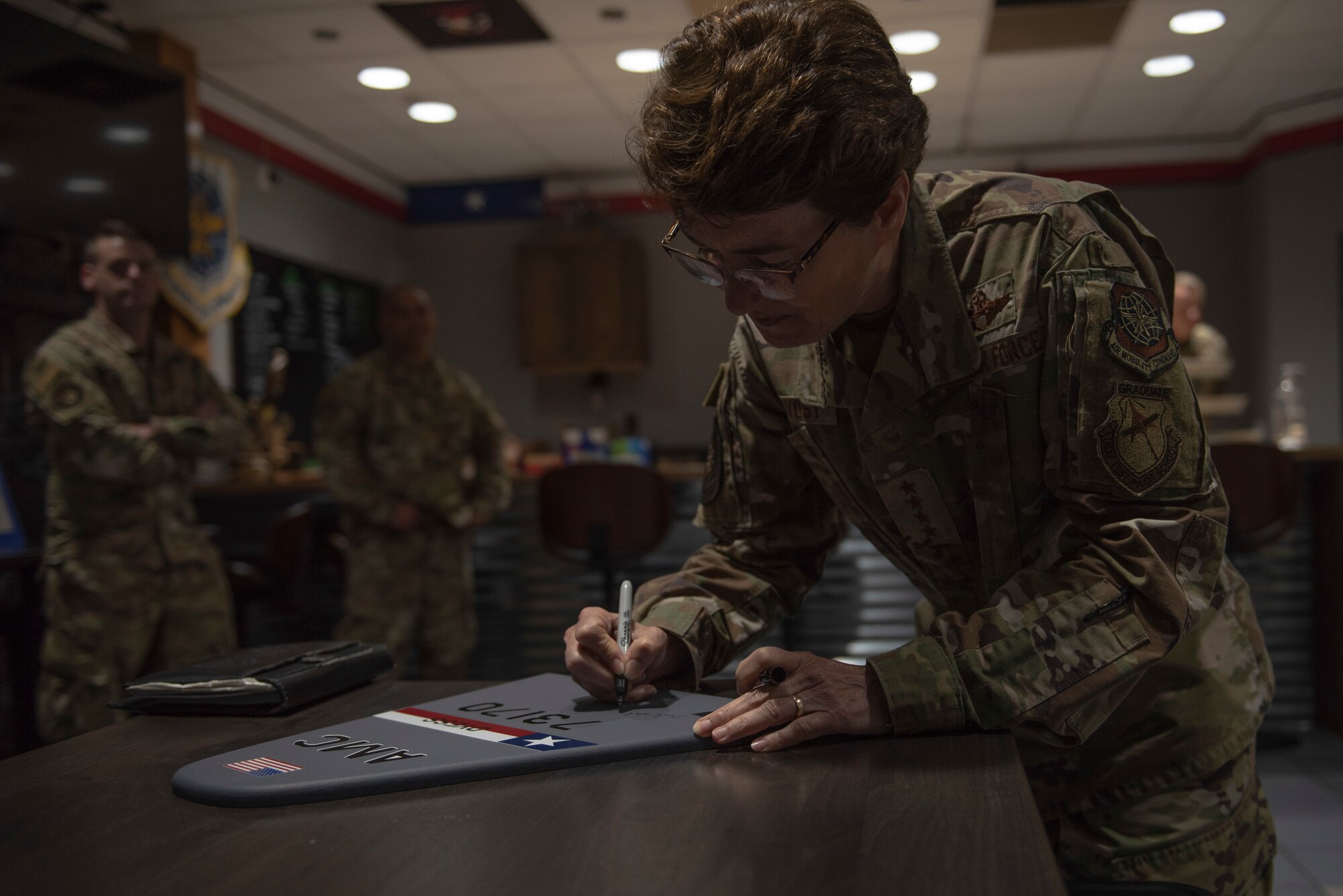 U.S. Air Force Gen. Jacqueline Van Ovost, Air Mobility Command commander, signs a C-130J Super Hercules tail flash at Dyess Air Force Base, Texas, July 8, 2021. The 317th Airlift Wing traditionally has distinguished visitors sign a tail flash to commemorate their visit. (U.S. Air Force photo by Senior Airman Colin Hollowell)