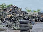 tires stacked in front of a scrap pile