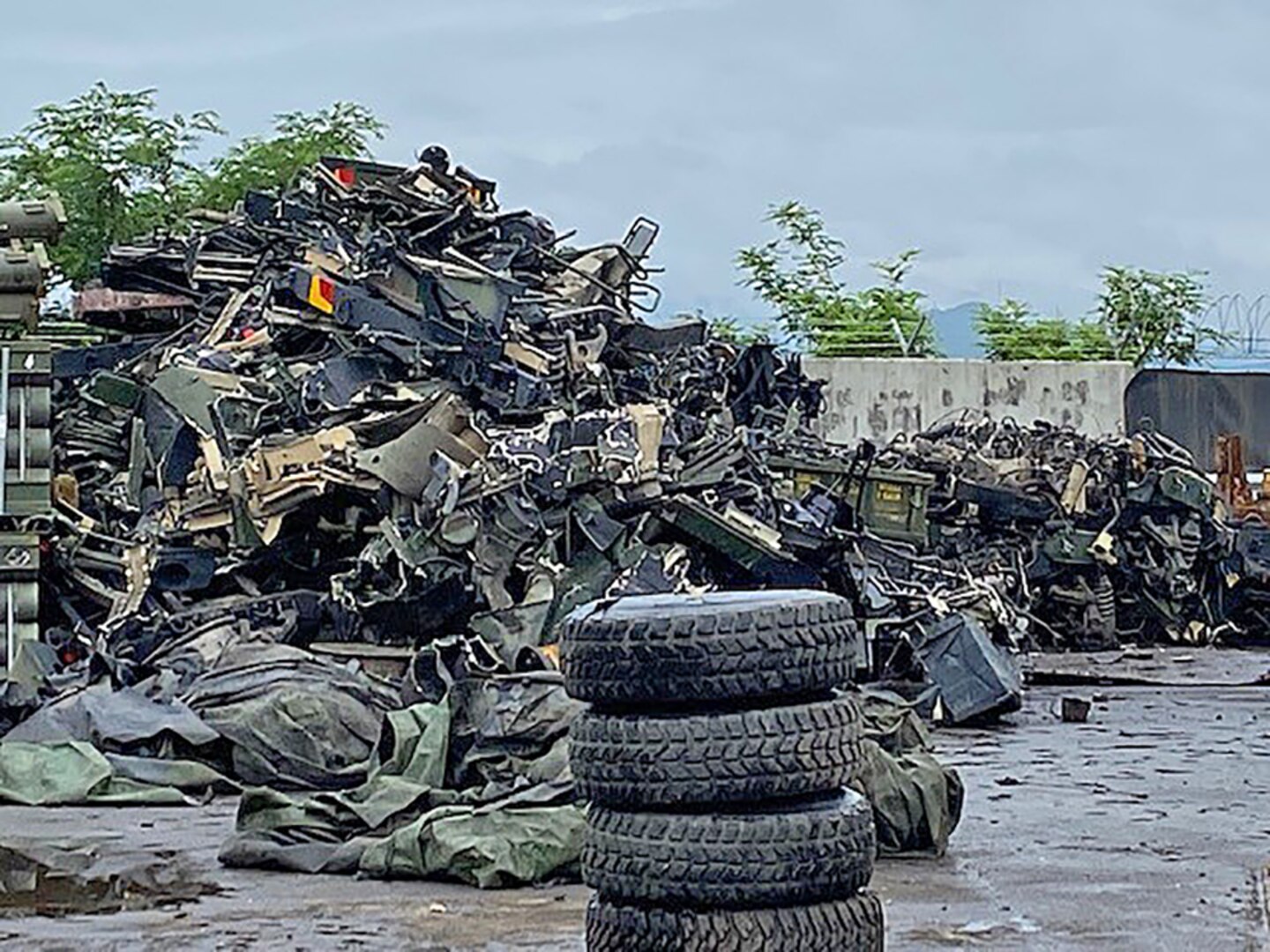 tires stacked in front of a scrap pile