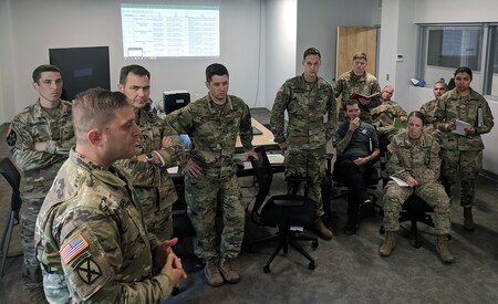 Task force commander and battalion commander for exercise Operation Tiger Stance (second from left),  briefs members of the 154th and 155th Cyber Protection Teams on mission defense plans for the exercise, at the the Indiana National Guard's Muscatatuck Urban Training Center, Ind., Aug. 19, 2018.