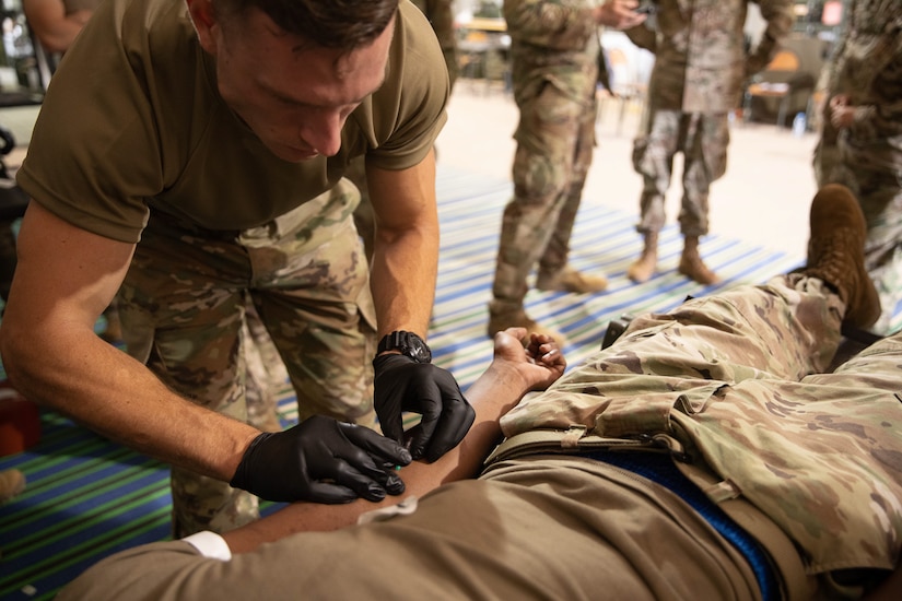 U.S. Army Spc. Spencer Fayles of the 144th Area Support Medical Company treats a fellow Soldier, June 8, 2021, at Cap Draa Maneuver Area, Morocco.