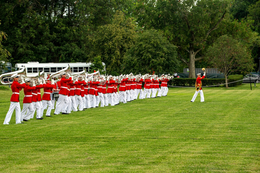 Marines with “The Commandant’s Own,” U.S. Marine Drum and Bugle Corps, perform during the Tuesday Sunset Parade at the Marine Corps War Memorial, Arlington, Va., July 13, 2021. The hosting official for the evening was Brig. Gen. George B. Rowell IV, Director of Communication, Headquarters, Marine Corps, and the guest of honor was Vice Admiral Sean Buck, Superintendent of the United States Naval Academy. (U.S. Marine Corps photo by Lance Cpl. Allen Sanders)