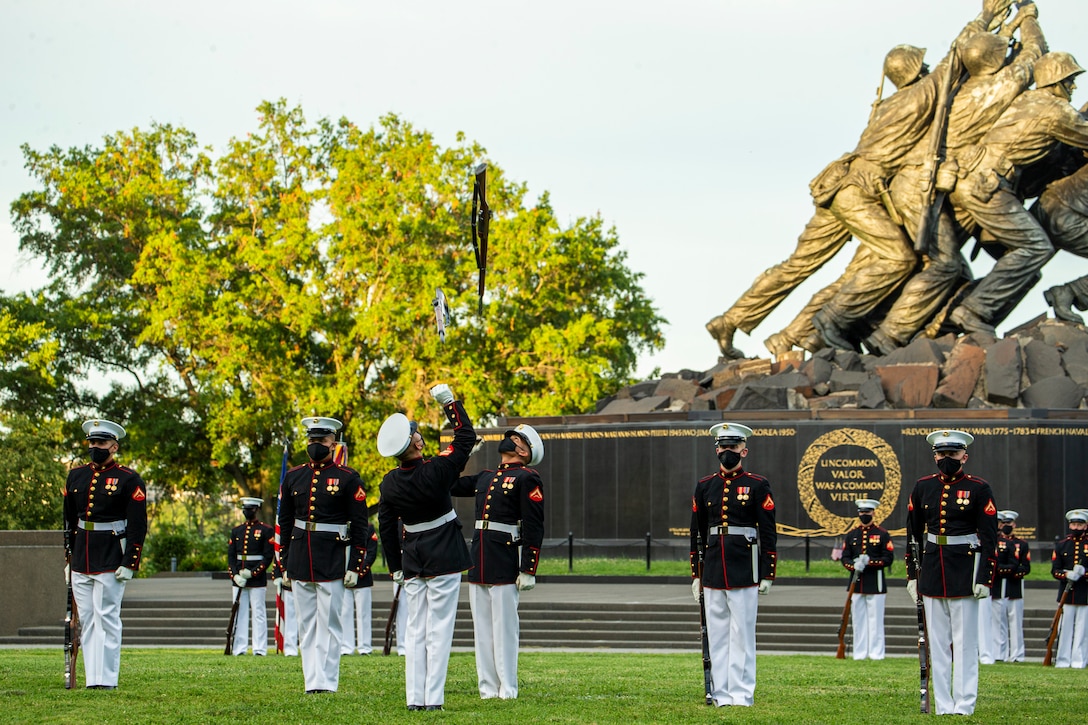 Marines with the Silent Drill Platoon execute their “rifle inspection” sequence during the Tuesday Sunset Parade at the Marine Corps War Memorial, Arlington, Va., July 13, 2021. The hosting official for the evening was Brig. Gen. George B. Rowell IV, Director of Communication, Headquarters, Marine Corps, and the guest of honor was Vice Admiral Sean Buck, Superintendent of the United States Naval Academy. (U.S. Marine Corps photo by Lance Cpl. Allen Sanders)