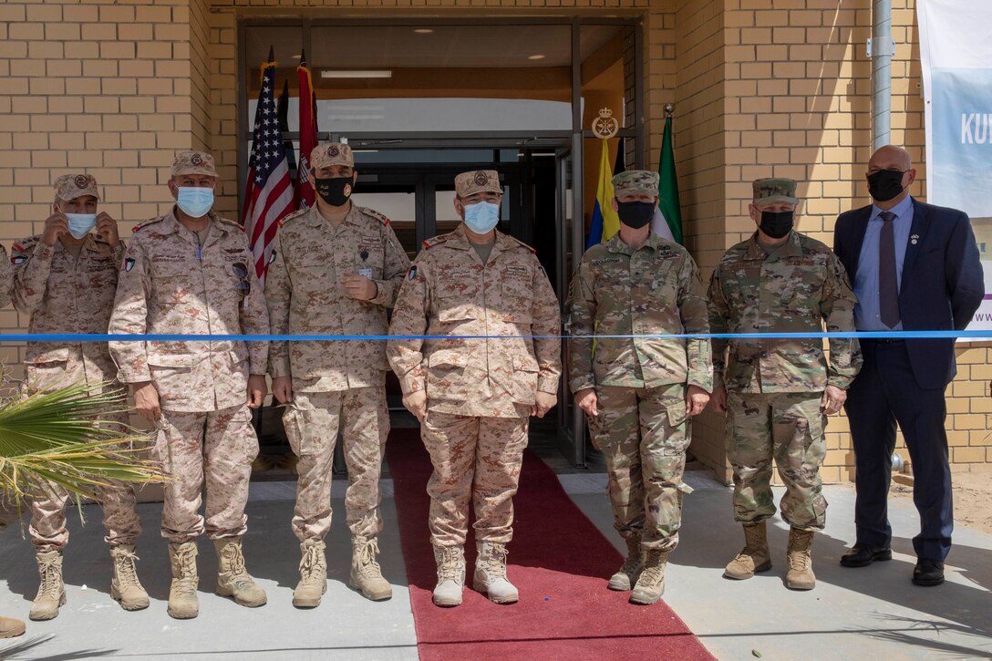Kuwaiti and American service members and civilians stand together before cutting the ribbon at the new Patriot Fire Site, Site #7, Kuwait, July 5, 2021. Both American and Kuwaiti organizations came together to plan, design, resource, and construct the new Patriot Fire Unit Site, Site #7.