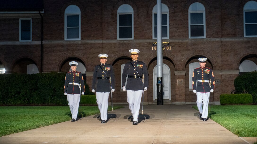 Marines with the Parade Staff march down Center Walk during the Friday Evening Parade at Marine Barracks Washington, July 9, 2021. The hosting official for the evening was Gen. David H. Berger, Commandant of the Marine Corps, and the guest of honor was The Honorable Thomas W. Harker, Acting Secretary of the Navy. (U.S. Marine Corps photo by Sgt. Jason Kolela)