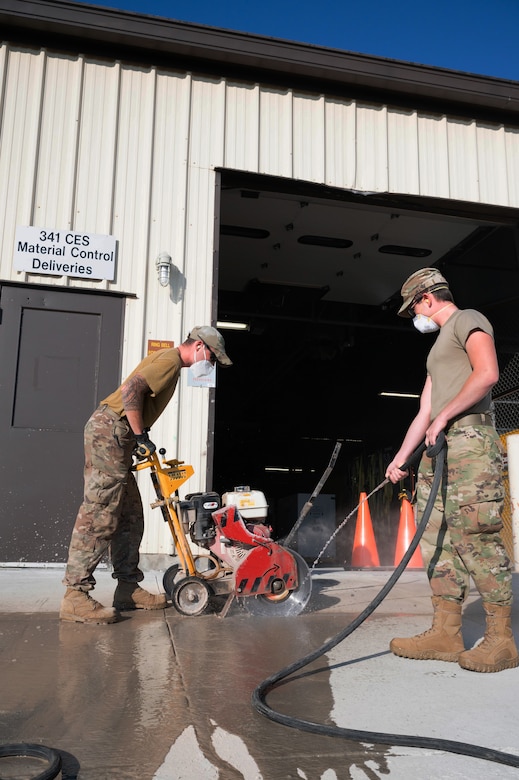 Airman 1st Class Christian Atkins, left, and Senior Airman Garrett Cothran, right, 341st Civil Engineer Squadron heavy equipment operators, make relief cuts into new concrete July 14, 2021, at Malmstrom Air Force Base, Mont.