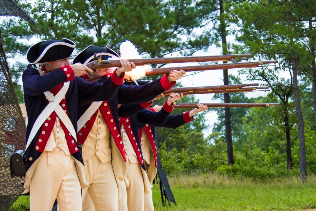 Four soldiers fire weapons.