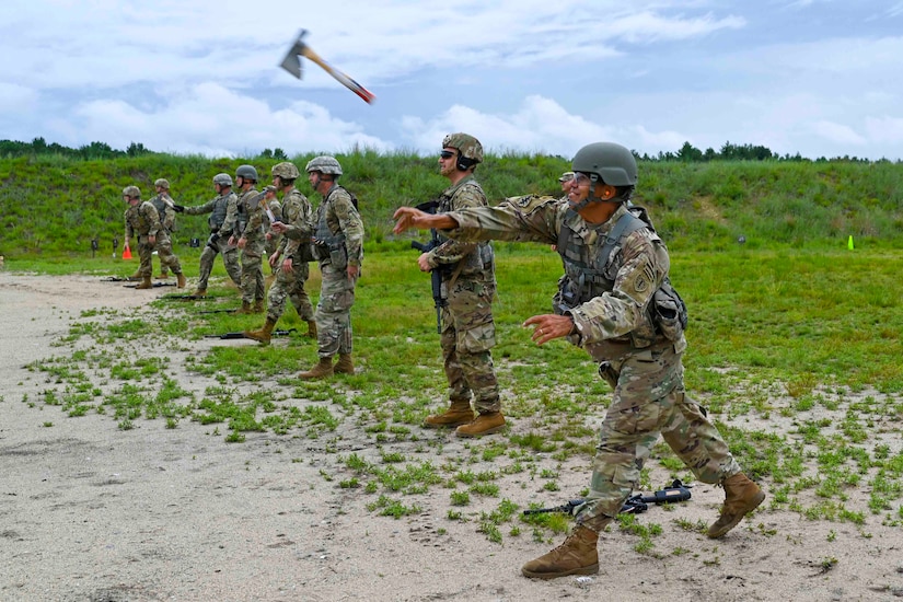 A guardsman throws a hatchet next to a group of other guardsmen.