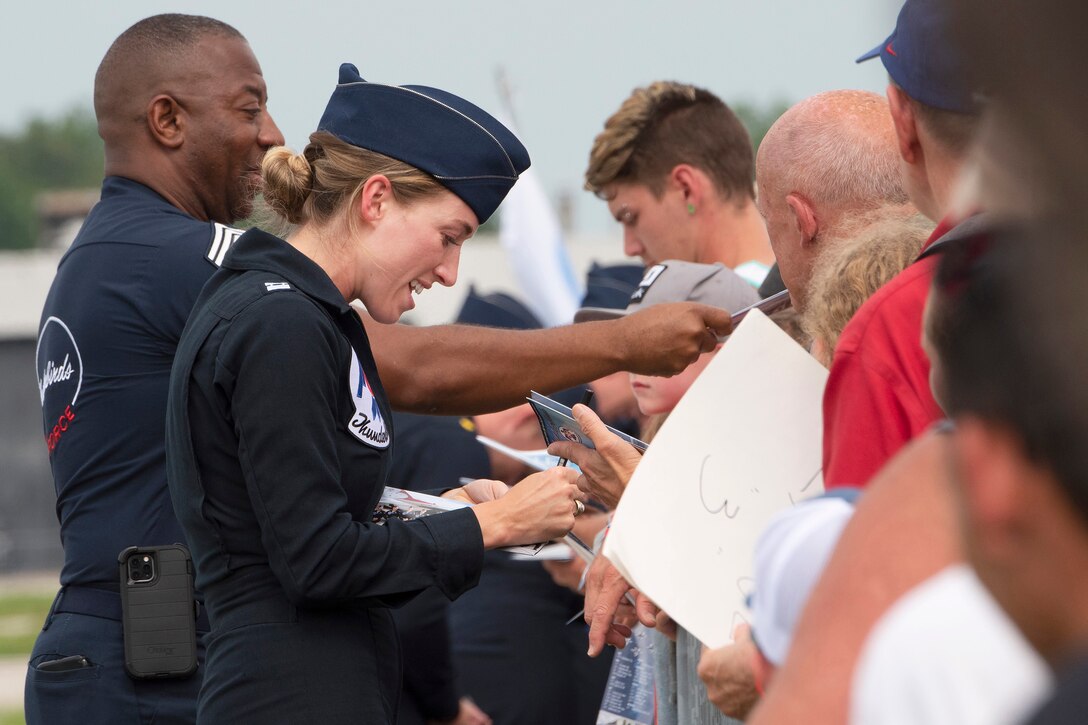Airmen sign autographs for fans.