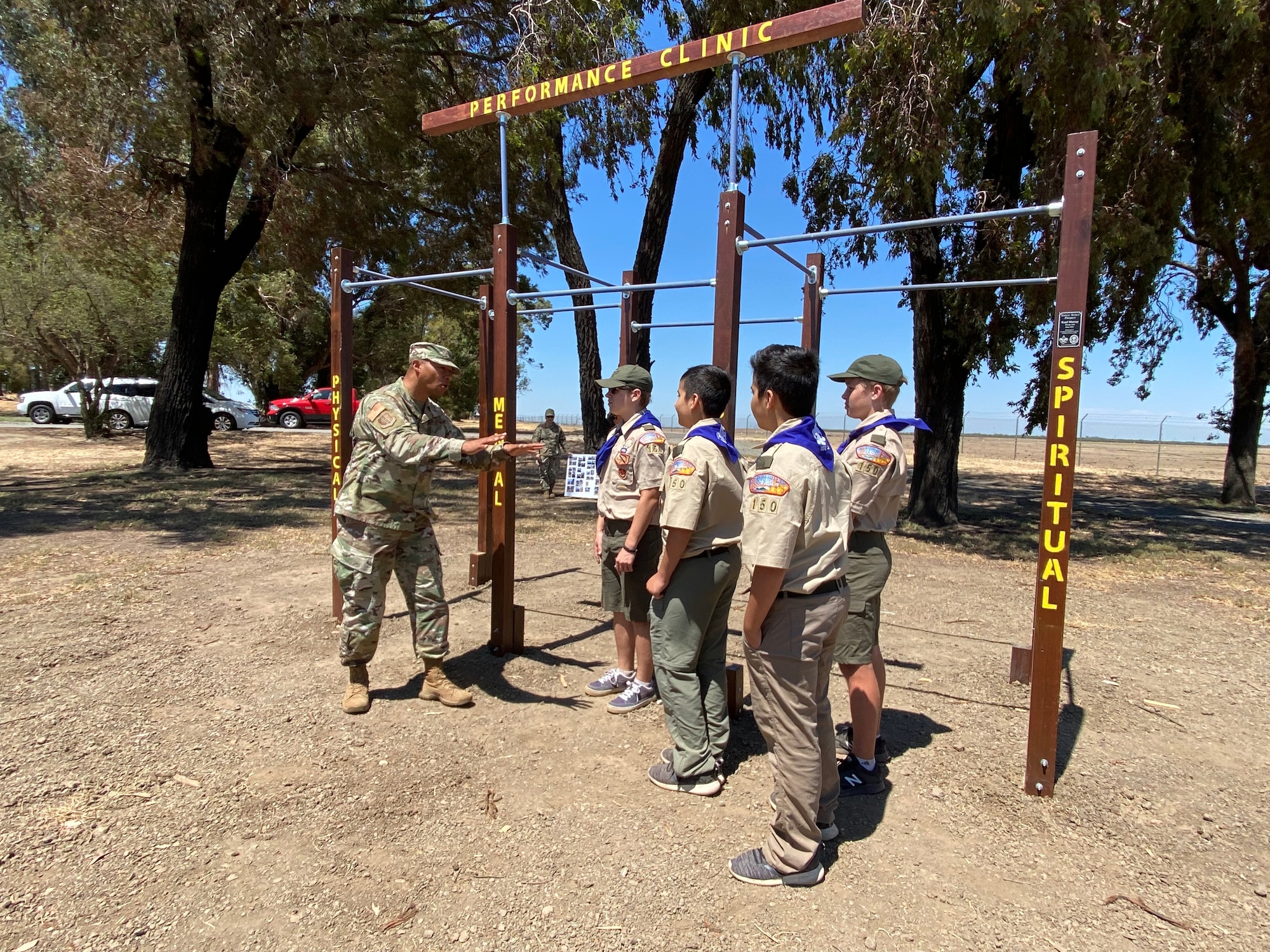 A gentleman in uniform talks with boy scouts.