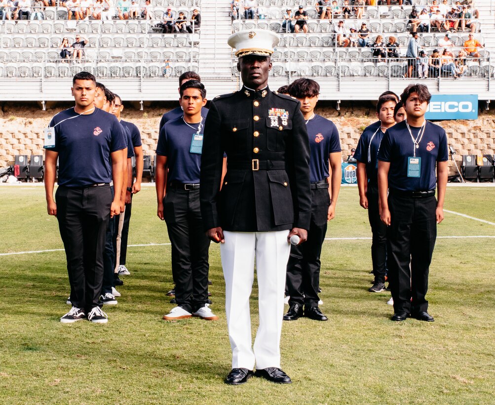 U.S. Marine Corps Major Gordon Emmanuel, the commanding officer for Recruiting Station Orange County, stands with future Marines before facilitating the oath of enlistment in San Diego, California, on July 3, 2021. Recruiting Station Orange County attended the San Diego Loyals soccer game and conducted a swear-in ceremony in honor of Independence Day. (U.S. Marine Corps photo by Sgt. Sarah Ralph)