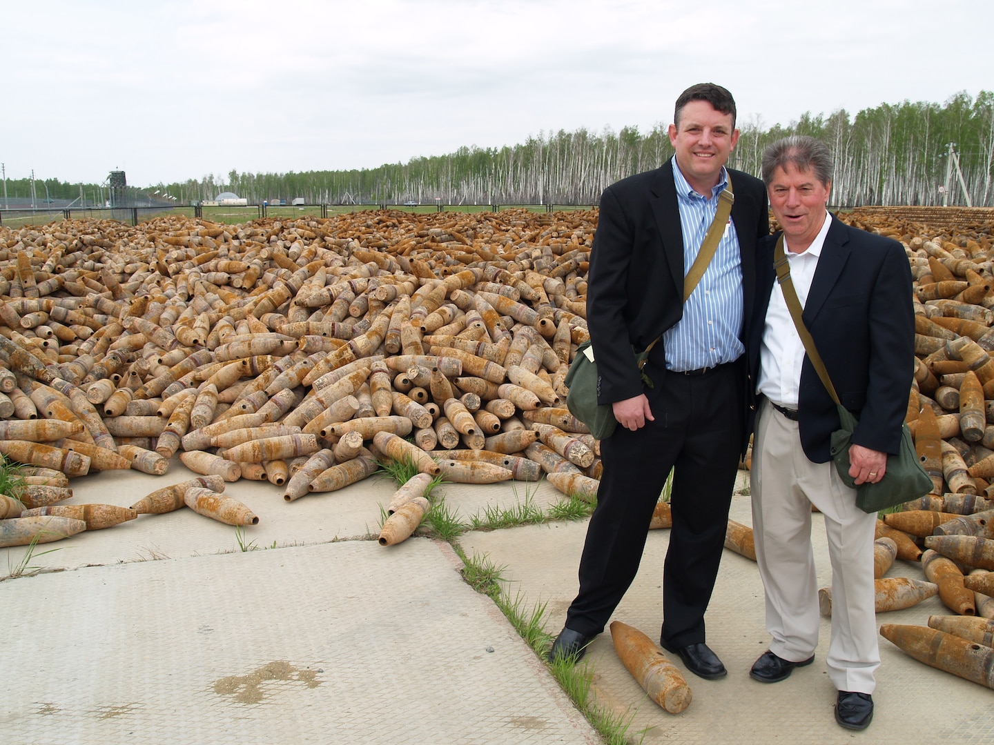 Scott Crow (left) and Paul McNelly stand in front of a stockpile of destroyed chemical weapons munitions in Russia in 2011.