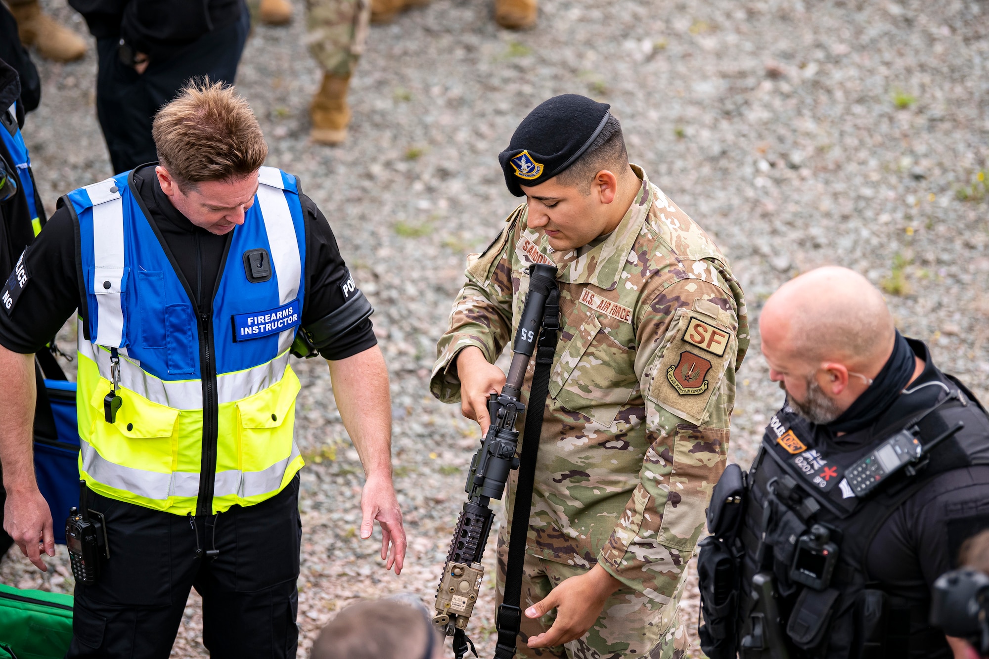 Staff Sgt. Carlos Sandoval, center, 422nd Security Forces Squadron unit trainer, demonstrates an M4 carbine to police officers from Northamptonshire Police Department and Ministry of Defense prior to a tri-agency active shooter response exercise at RAF Croughton, England, June 30, 2021. Airmen from the 422nd SFS along with police officers from the NHPD and MOD, participated in multiple exercises to enhance their search and seizure tactics, strengthen local ties and gain rapport with their fellow officers. (U.S. Air Force photo by Senior Airman Eugene Oliver)